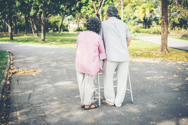 Premium Photo | Assisting her senior patient who's using a walker for ...