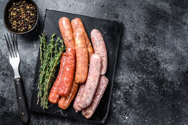 Premium Photo | Assorted raw homemade sausages on a stone board. top view.