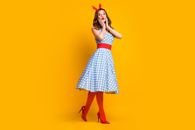 Premium Photo | Astonished girl in dotted blue dress go on yellow ...