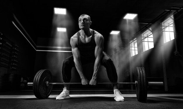 Premium Photo | Athlete is standing on his knee and near the bar and is ...