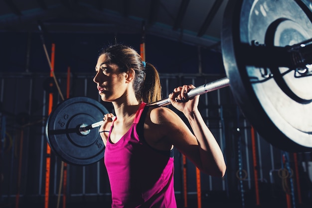 Premium Photo | Athletic girl works out at the gym with a barbell