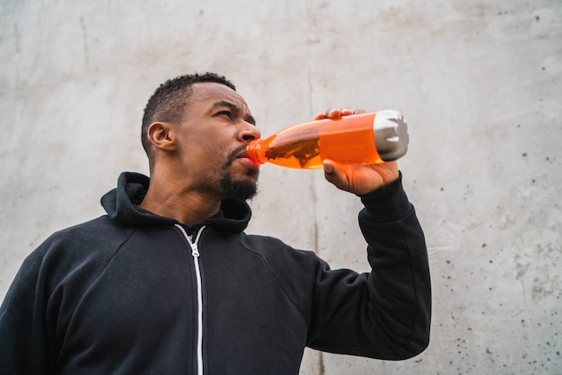 Premium Photo | Athletic man drinking something after training.