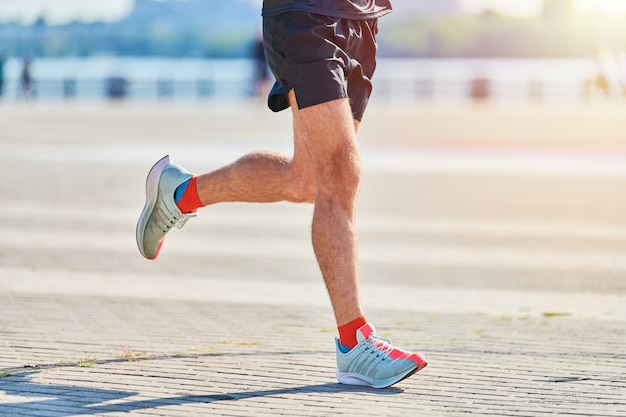 Premium Photo | Athletic man jogging in sportswear on city road