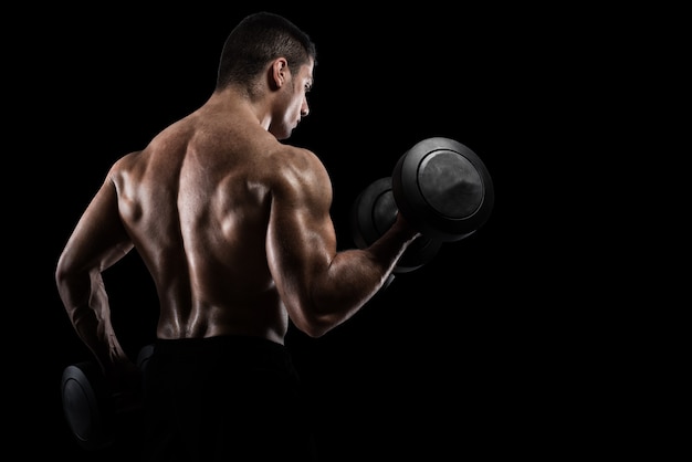 Premium Photo | Athletic muscular man training biceps with dumbbells