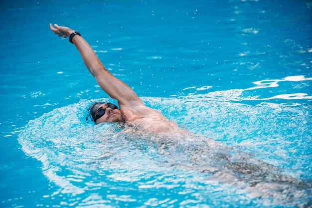 背泳ぎスタイルで泳ぐ運動青年 水泳大会 プレミアム写真