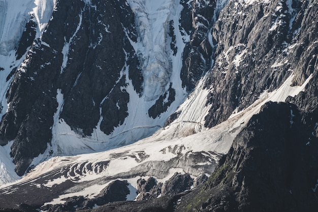 Premium Photo Atmospheric Minimalist Textured Alpine Landscape Of Snowy Rocky Mountain With Glacier Tongue Snowbound Mountainside Cracks On Ice On Steep Slope Majestic Scenery On High Altitude
