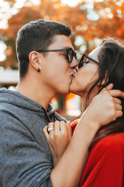 魅力的なカップル愛好家は公園でキスします 無料の写真