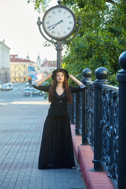 Premium Photo Attractive Girl Stands In Front Of A Large City Clock