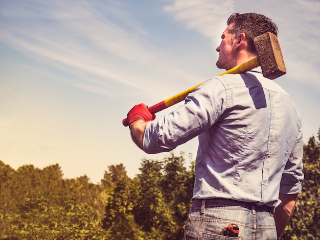 Premium Photo | Attractive guy with a sledgehammer