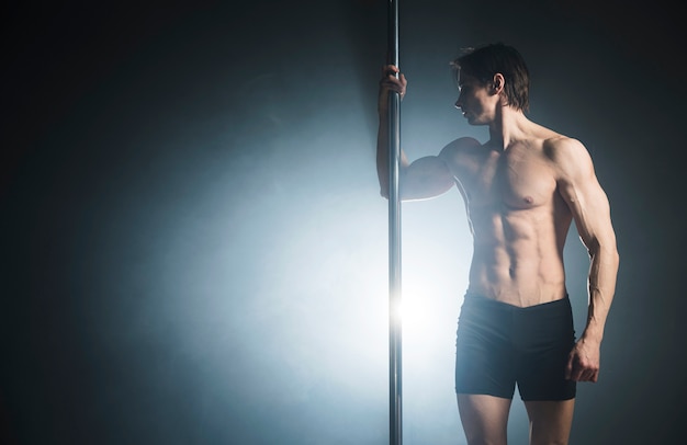 Free Photo Attractive Male Model Performing A Pole Dance 