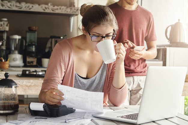 Free Photo | Attractive serious female in spectacles drinking coffee ...