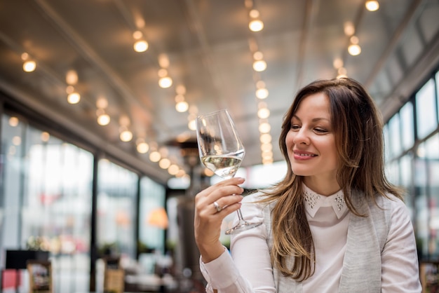 Premium Photo | Attractive young woman in cafe restaurant tasting wine.