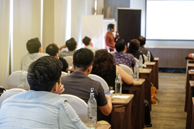 Audience listening speaker who standing in front of the room at the conference hall Premium Photo