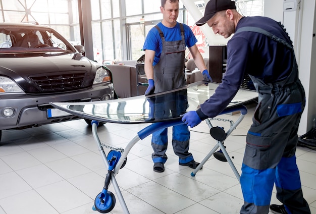 Premium Photo | Automobile special workers replacing windscreen or