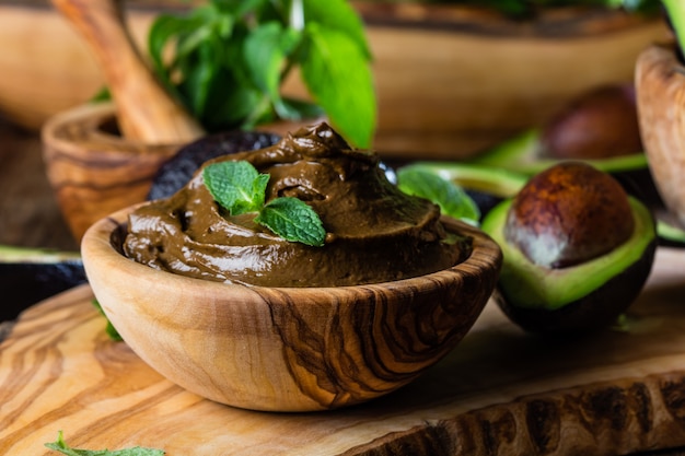Avocado chocolate mousse in olive wooden bowl Premium Photo
