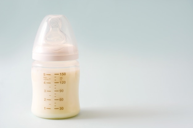 Baby bottle and milk on gray Premium Photo