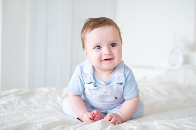 Premium Photo | Baby boy 6 months old in blu clothes smiling and ...