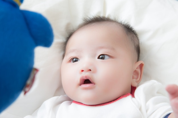 Premium Photo | Baby boy looking at the doll