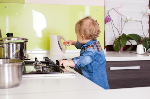 Premium Photo | Baby boy tries to turn on the gas stove alone