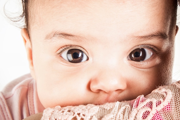 ピンクのシャツに黒い目をした赤ちゃんの顔 無料の写真