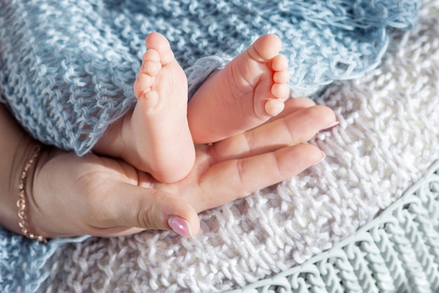 母の手で赤ちゃんの足 女性の形をした手のクローズアップの小さな新生児の足 ママと彼女の子供 マタニティの美しい概念イメージ プレミアム写真