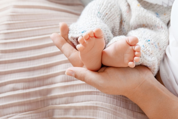 Baby feet in mother hands. tiny newborn baby's feet on ...