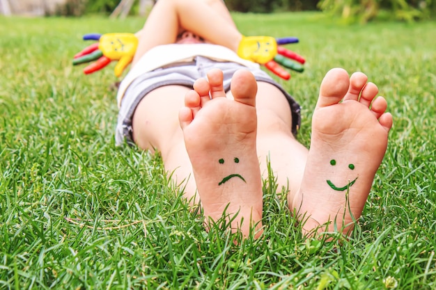 Premium Photo | Baby feet with paint pattern are smiling and sad on the ...