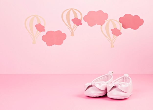 雲と風船とピンクのパステル背景に女の赤ちゃんかわいいピンクの靴 プレミアム写真