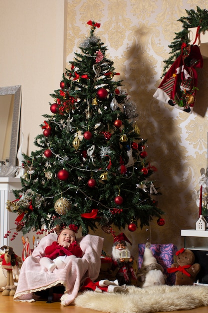ぬいぐるみのクリスマスツリーの下の女の赤ちゃん 無料の写真