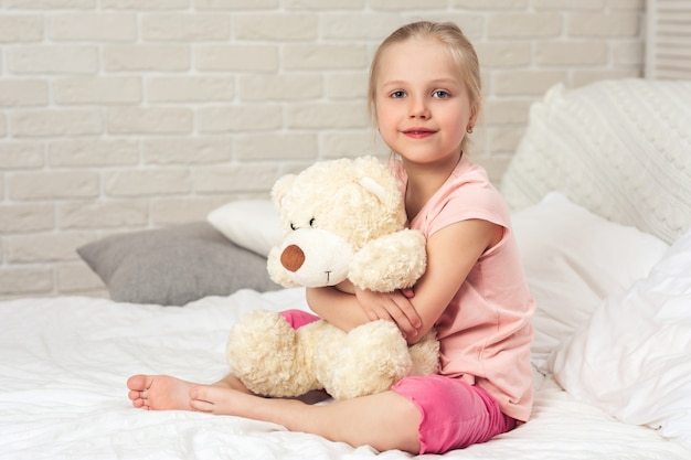 baby hugging teddy bear