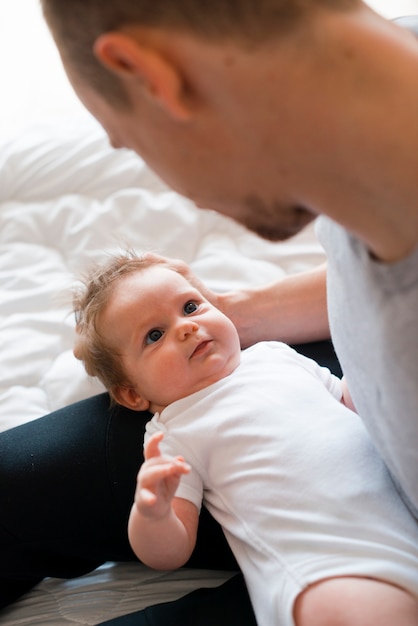 Free Photo Baby Laying On Knees Of Dad