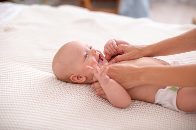 Baby massage. a mother gives a massage to her newborn child. Premium Photo