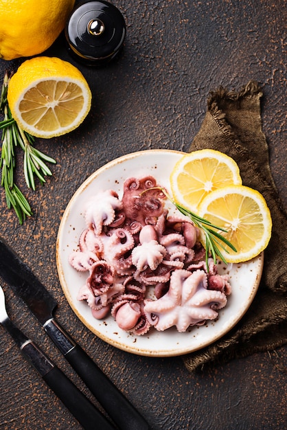 Premium Photo | Baby octopus in plate with lemon and rosemary