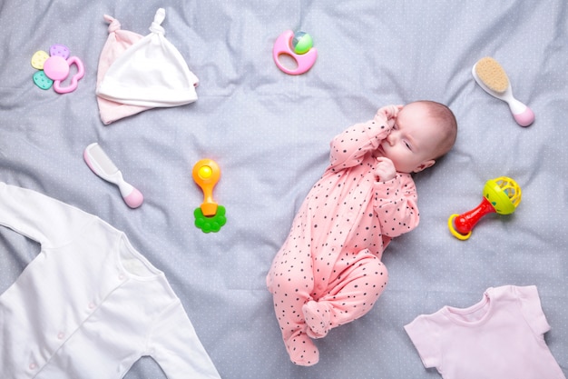 Premium Photo | Baby on white with clothing, toiletries, toys and ...