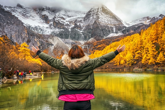 antyder annoncere Tectonic Premium Photo | Back side of asian traveler woman looking and sightseeing  over the pearl lake with snow mountain in autumn season in yading nature  reserve, china.travel and tourism,famous place and landmark