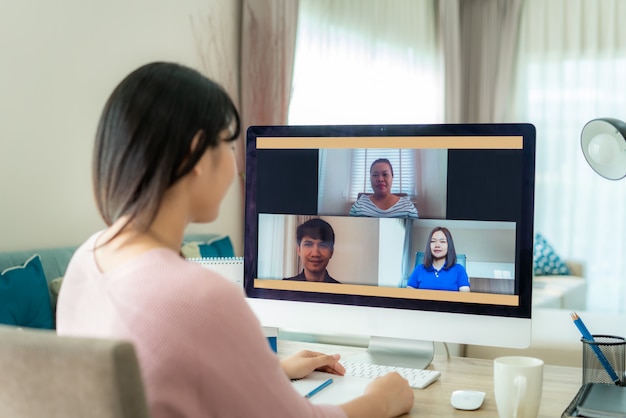 Back view of asian business woman talking to her colleagues about plan in video conference. Premium Photo