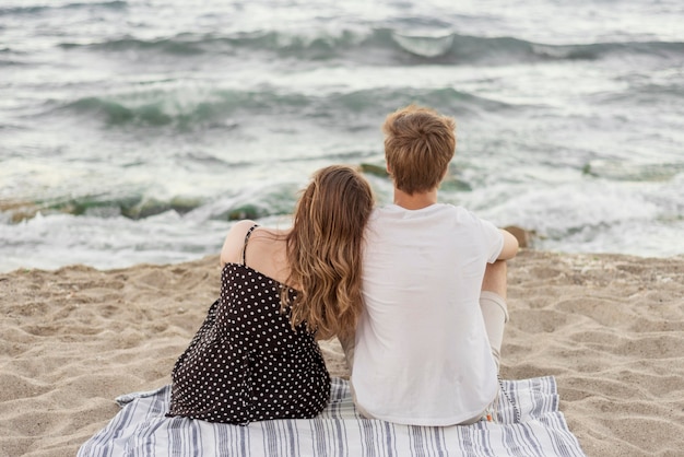 Free Photo | Back view boy and girl staying together on the beach