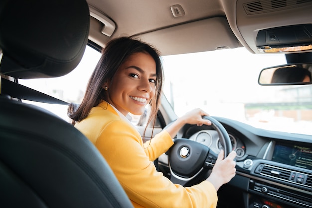 Back View Of A Confident Smiling Woman Driving Car Premium Photo