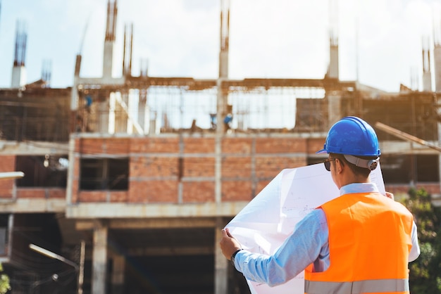 Premium Photo | Back view of engineer with blue safety helmet checking ...