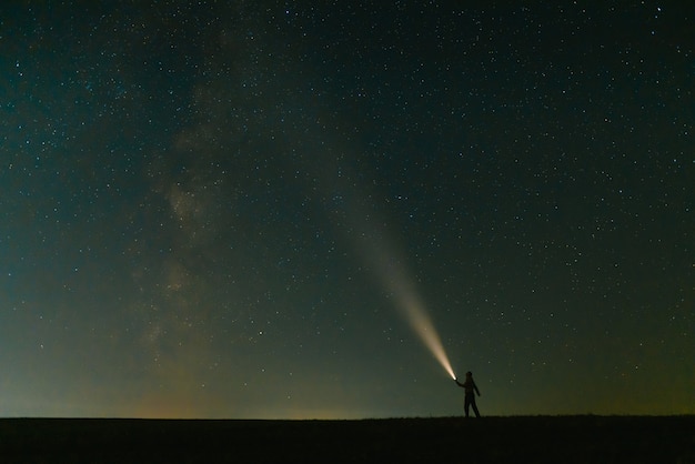 Premium Photo | Back view of man with head flashlight standing on green ...