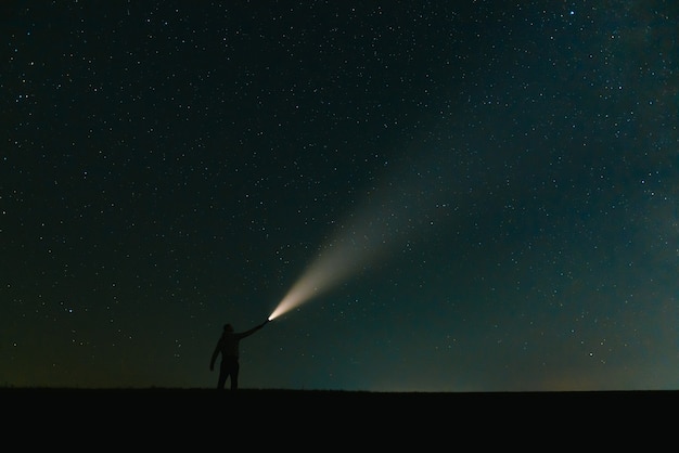Premium Photo | view of man with flashlight standing on green grassy field beautiful dark blue starry