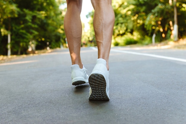 Premium Photo | Back view of muscular sportsman legs running