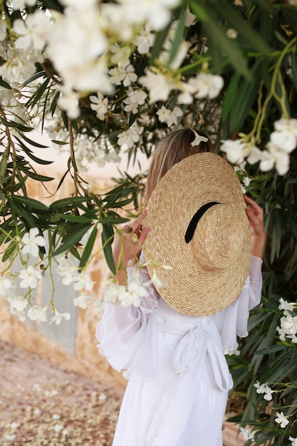 白いドレスと麦わら帽子の美しい少女の後ろ姿 プレミアム写真