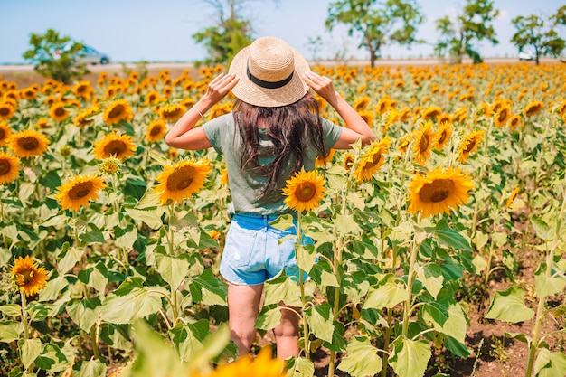 ひまわり畑で麦わら帽子の女性の後ろ姿 夏の時間 プレミアム写真