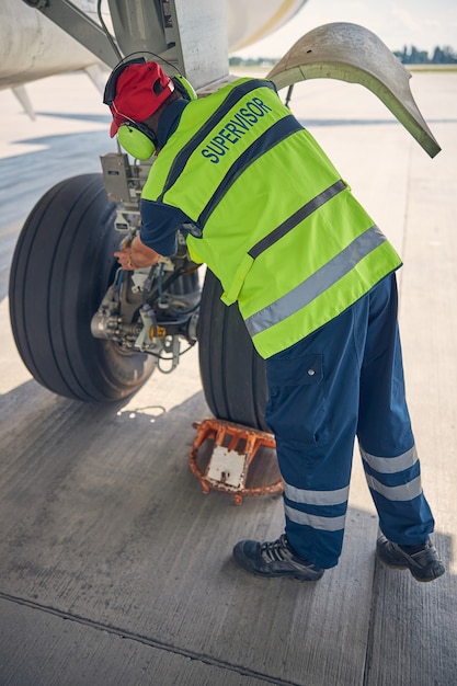 Premium Photo | Back view of a qualified aircraft mechanic in a safety ...