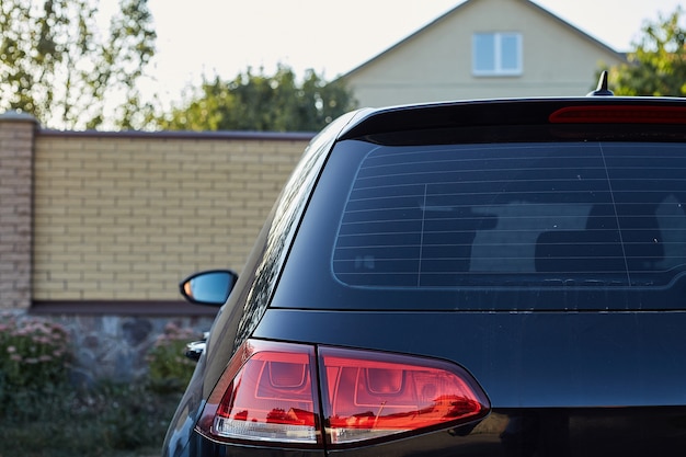 夏の晴れた日 背面に路上駐車した黒い車の後ろの窓 ステッカーやデカールのモックアップ プレミアム写真