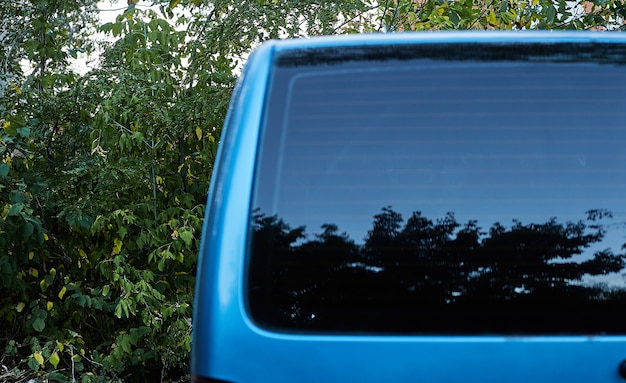 夏の晴れた日 リアビューで路上駐車している青い車の後ろの窓 ステッカーやデカールのモックアップ プレミアム写真