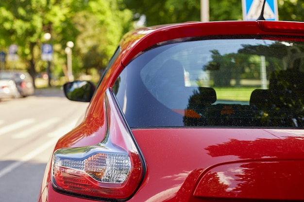 夏の晴れた日 背面に路上駐車の赤い車の後ろの窓 ステッカーやデカールのモックアップ プレミアム写真
