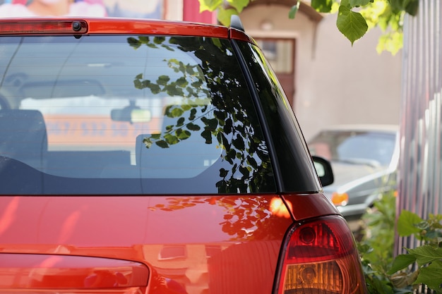 Premium Photo | Back window of red car parked on the ...