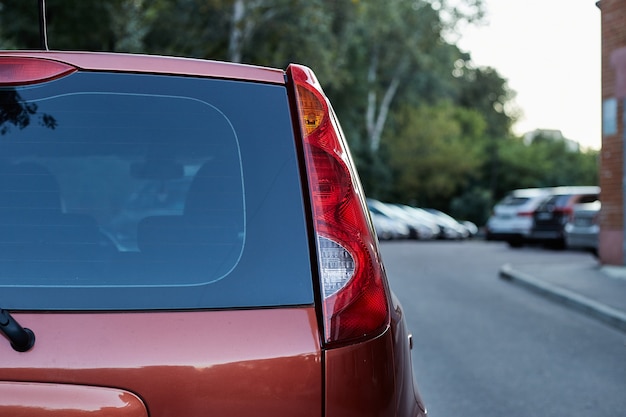 Download Premium Photo | Back window of red car parked on the street in summer sunny day, rear view. mock ...